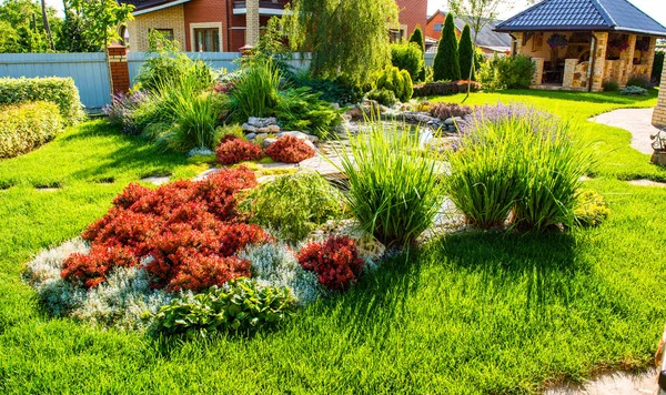 Beautiful backyard landscape design. View of colorful trees and decorative trimmed bushes  rocks Stock Photo