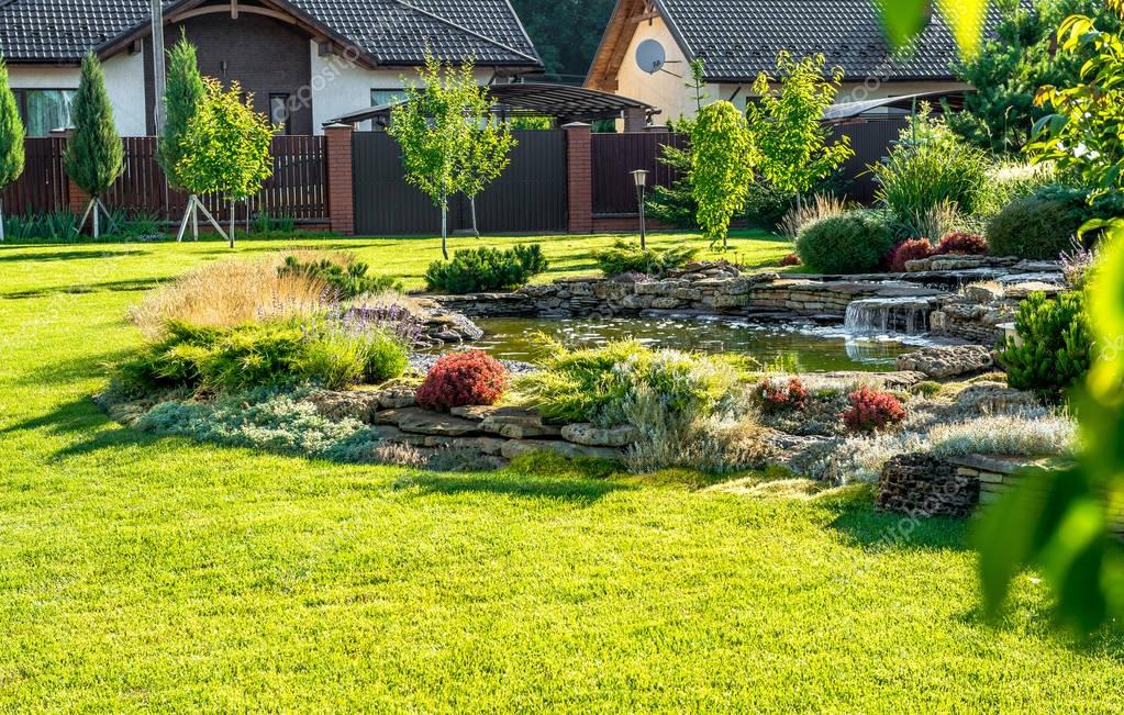 Diseño del paisaje patio trasero hermoso. Vista de árboles coloridos y