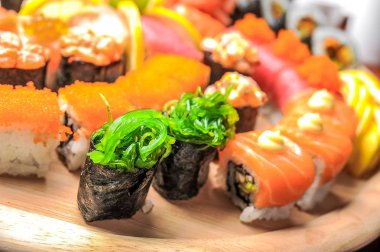 Nigiri suşi ve rulo ile balık üzerinde ahşap masa servis
