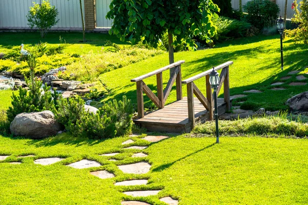 Hermoso diseño de paisaje patio trasero. Vista de árboles coloridos y arbustos decorativos recortados rocas — Foto de Stock