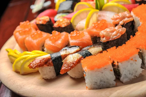 Sushi Nigiri e panini con pesce serviti sul tavolo di legno — Foto Stock