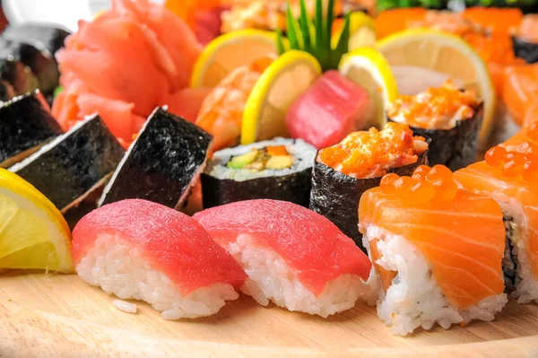 Sushi nigiri e rolos com peixe servido em mesa de madeira — Fotografia de Stock