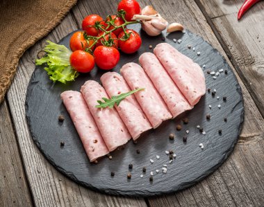 Ahşap bir arka plan üzerinde jambon sosis kesme