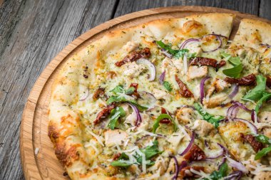 Pizza güneşte kurutulmuş domates, jambon, roka ve parmesan peyniri ile