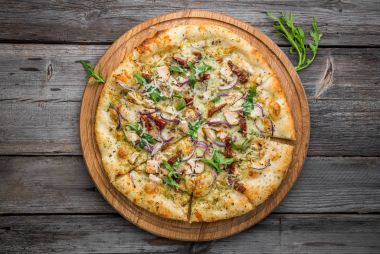 Pizza güneşte kurutulmuş domates, jambon, roka ve parmesan peyniri ile