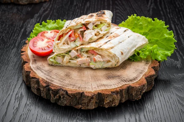 Tortilla envuelve con pollo a la parrilla o tarta vegetariana de verduras frescas sobre un fondo de madera . — Foto de Stock