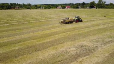 Ukrayna, Kalinovka, 4 Eylül 2017, saman balya üreten saman balya bir alanda - havadan görüntüleri ile yeşil traktör