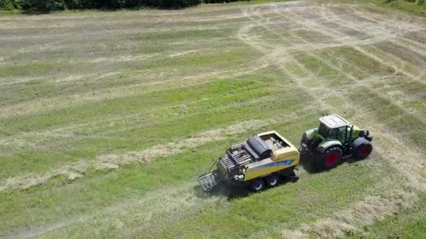 ウクライナ、Kalinovka、2017 年 9 月 4 日、グリーン フィールド - 空中映像で干し草ベーラーの生産干し草の俵トラクター — ストック動画