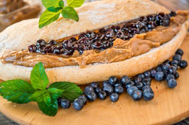 Fıstık ezmesi, reçel ve Beyaz ahşap zemin üzerine taze meyve ile sandviç