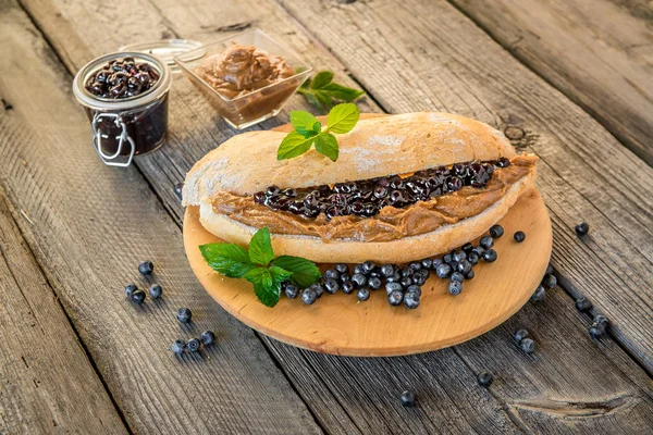 Smörgåsar med jordnötssmör, sylt och färsk frukt på vit trä bakgrund — Stockfoto