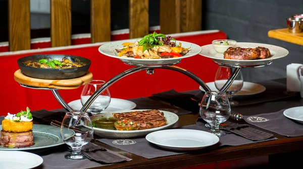 Primo piano della tavola tagliata con cibi e piatti diversi, carne, frutta, pesce nel ristorante . — Foto Stock
