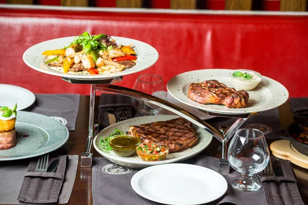 Close-up de mesa cortada com diferentes alimentos e pratos, carne, frutas, peixe no restaurante . — Fotografia de Stock