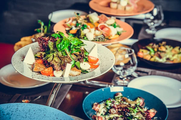 Muitos pratos diferentes no restaurante, placa branca na mesa com prato lateral , — Fotografia de Stock