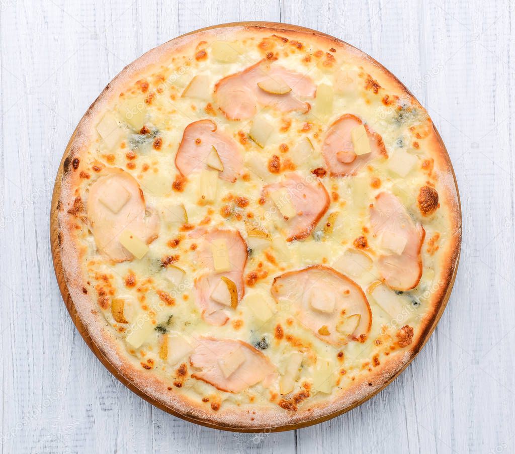 Pizza with ham, apples and pineapple
