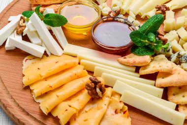 çeşitli peynir siyah barut, fındık ve bal, üzüm ile dekore edilmiş ve nane yaprakları