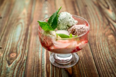 Ev yapımı kızılcık dondurması ve ahşap bir kasede nane filizi.