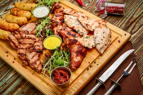 Diverse heerlijke gegrild vlees en groenten met verse salade en bbq saus op snijplank op houten achtergrond. Grote set van Hot Meat Dishes — Stockfoto