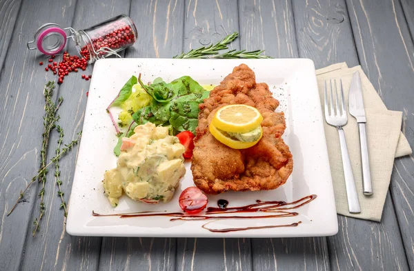 Wiener Schnitzel with potato salad and lemon — Stock Photo, Image