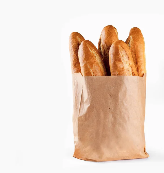 Pan de baguette en bolsa de papel sobre fondo blanco —  Fotos de Stock