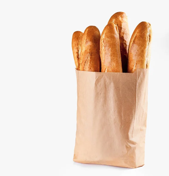 Pão de baguete em saco de papel sobre fundo branco — Fotografia de Stock