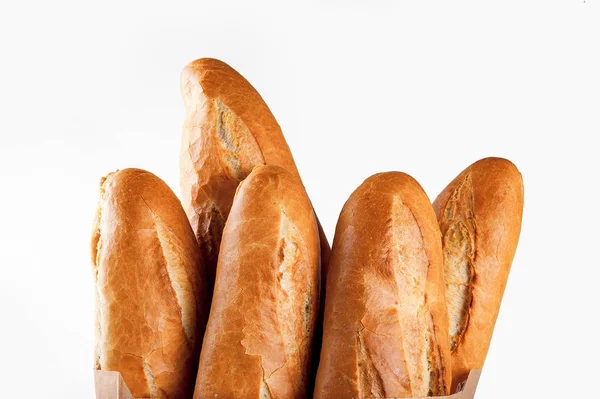 Baguette bread in paper bag on white background — Stockfoto