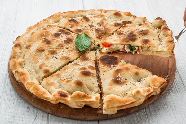 Pie with meat, vegetables and cheese on a wooden background — Stock Photo, Image