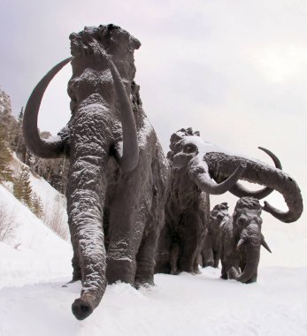 Khanty-Mansiysk, Rusya 17 Şubat 2018: Ücretsiz giriş Event: Archeopark yünlü Mamutlar heykelleri. Buzul tepenin eteğinde bulunan, Archeopark Tarih öncesi hayvanlar ve insanlar canlı heykelleri gösterir