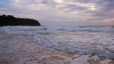 Sahilde güzel bir gün batımı. Dalgalar kıyıya vuruyor. Phuket, Tayland