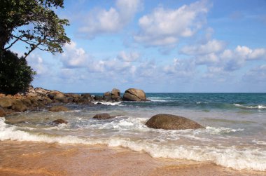Tropik plaj, sahilde kayalar, bulutlu mavi gökyüzü, Karon plajı, Phuket, Tayland
