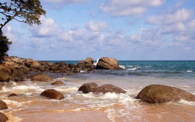 Tropik plaj, sahilde kayalar, bulutlu mavi gökyüzü, Karon plajı, Phuket, Tayland