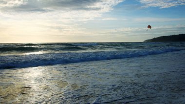 Beautiful sunset on tropical beach. The surf pounds the shore. Karon beach, Phuket, Thailand