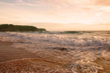 Beautiful sunset on tropical beach. The surf pounds the shore. Karon beach, Phuket, Thailand