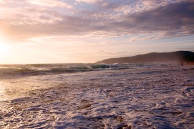 Beautiful sunset on tropical beach. The surf pounds the shore. Karon beach, Phuket, Thailand