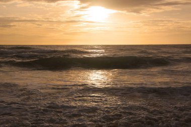 Beautiful sunset on tropical beach. The surf pounds the shore. Karon beach, Phuket, Thailand