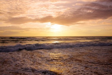 Beautiful sunset on tropical beach. The surf pounds the shore. Karon beach, Phuket, Thailand