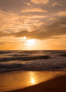 Beautiful sunset on tropical beach. The surf pounds the shore. Karon beach, Phuket, Thailand