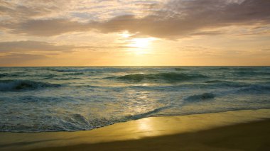 Beautiful sunset on tropical beach. The surf pounds the shore. Karon beach, Phuket, Thailand
