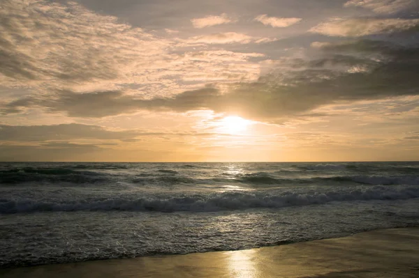 Beautiful sunset on tropical beach. The surf pounds the shore. Karon beach, Phuket, Thailand