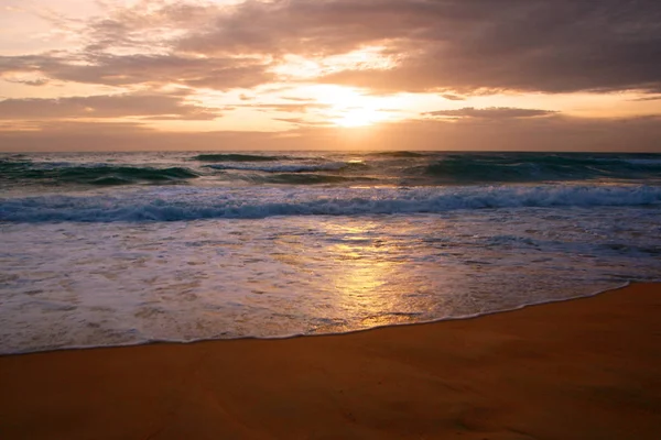 Beautiful sunset on tropical beach. The surf pounds the shore. Karon beach, Phuket, Thailand