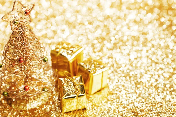 Hermoso árbol de Navidad decorativo dorado y regalos sobre fondo de brillo dorado —  Fotos de Stock