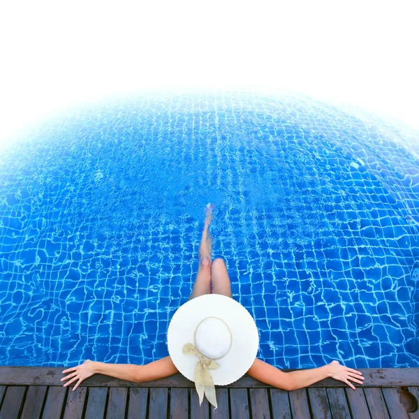 Mulher de chapéu relaxante na piscina — Fotografia de Stock