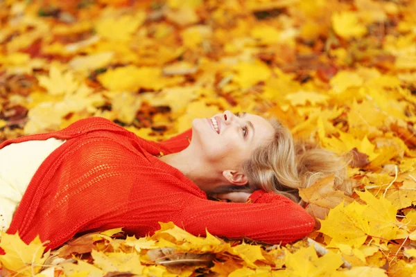 Vrouw opleggen Herfstbladeren — Stockfoto