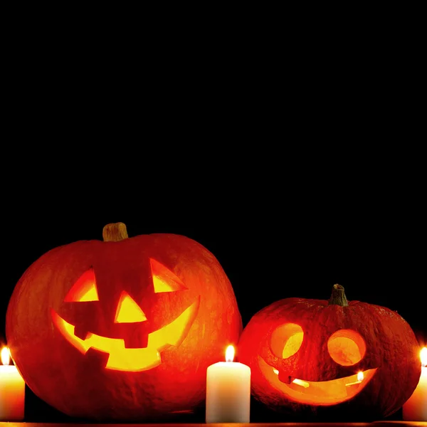 Funny Halloween pumpkin and burning candles on black background — Stock Photo, Image