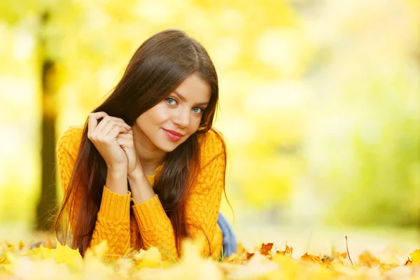 Cute woman laying in autumn park — Stock Photo, Image
