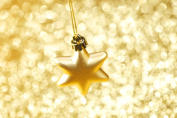 Golden christmas star on shining glitter background close-up — Stock fotografie