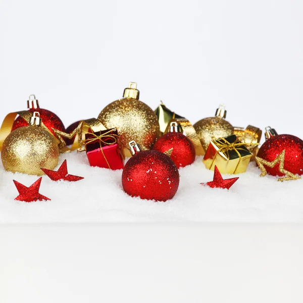 Рождественские шары на снегу — стоковое фото