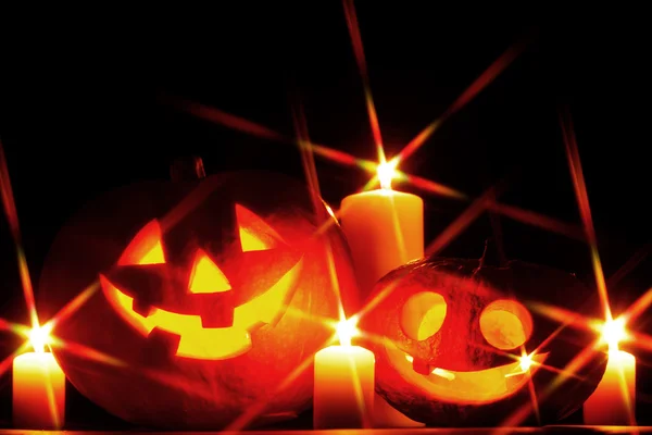 Divertente zucca di Halloween e candele accese su sfondo nero — Foto Stock