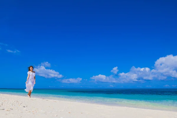 Mulher andando ao longo da praia — Fotografia de Stock