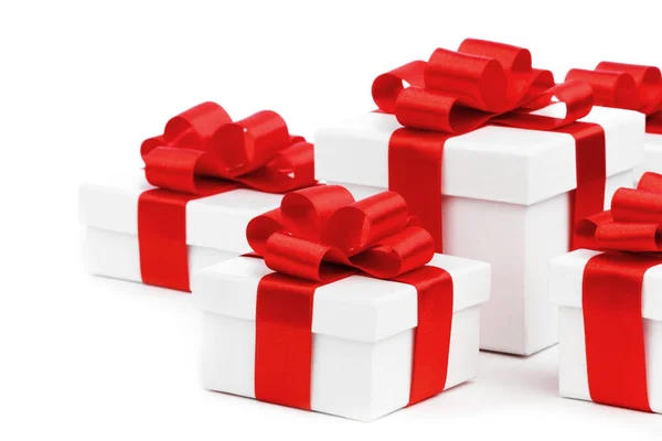 Белые подарочные коробки с красными лентами — стоковое фото