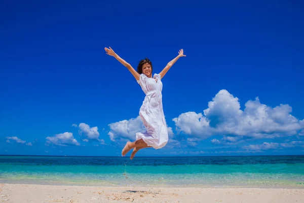 Vrouw springen op het strand — Stockfoto